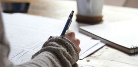 Persoon schrijft in notitieboekje