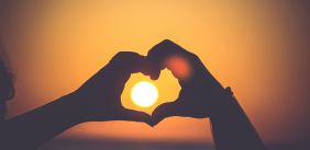 Twee mensen vormen een hart met hun hand