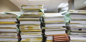 Stapels met mappen vol papier op een bureau