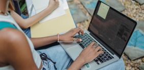 Persoon schrijft op een laptop