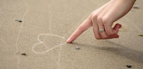 Vinger die een hartje tekent op de grond