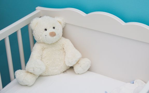 Wieg met een witte knuffelbeer erin