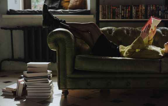 Persoon leest boek op de bank