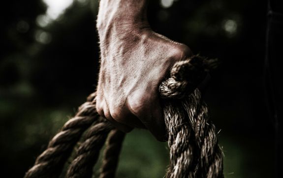 Hand houdt touw vast