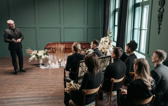 uitvaart waar iemand aan het spreken is met publiek