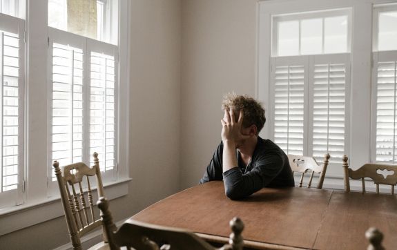 Foto Van Man Leunend Op Houten Tafel