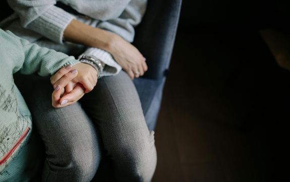 Moeder houdt hand van kind vast
