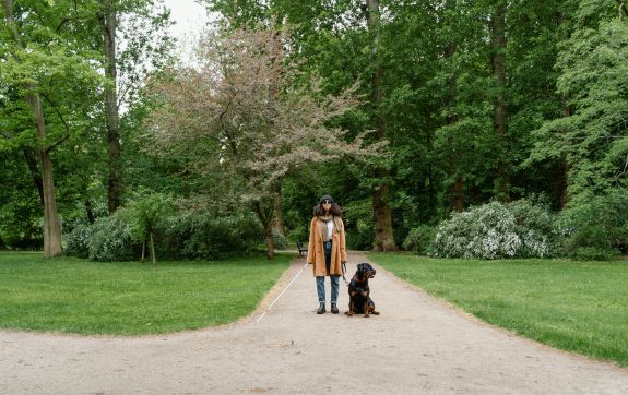 blinde vrouw met blindegeleidestok en blindegeleidehond