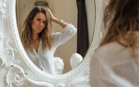 Vrouw kijkt in de spiegel