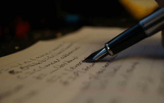 Een vulpen met een notitieboek vol met geschreven woorden