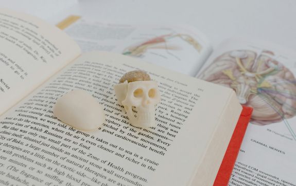 Medisch boek met skelet en medische instrumenten bovenop