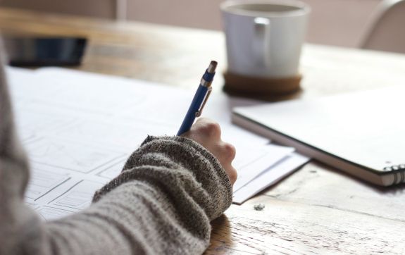 Persoon schrijft in notitieboekje
