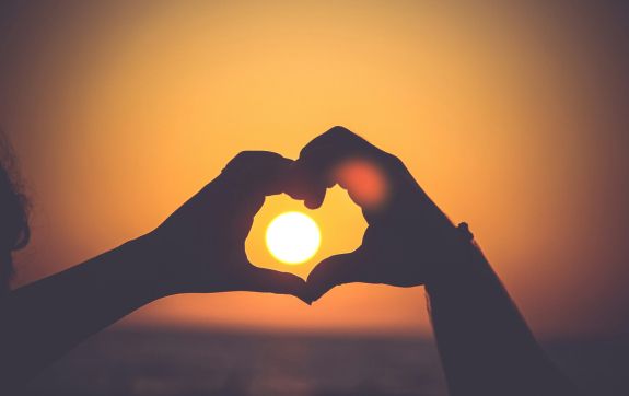 Twee mensen vormen een hart met hun hand