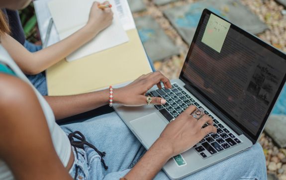Persoon schrijft op een laptop