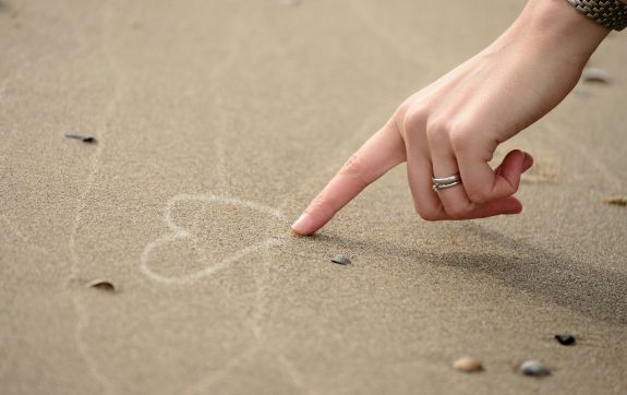 Vinger die een hartje tekent op de grond