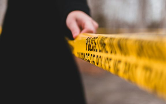 Persoon staat bij politielint