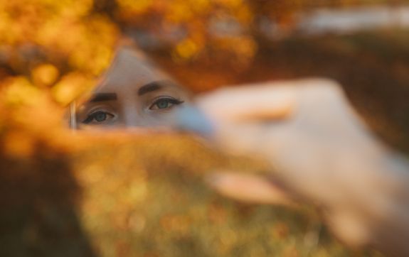 Een artistiek herfstportret dat de ogen van een vrouw vastlegt via een spiegelreflex