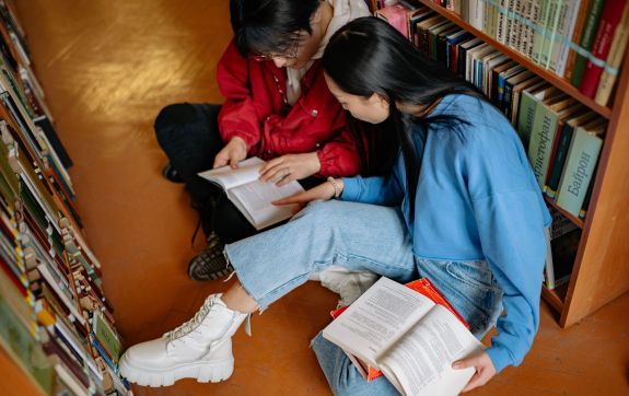 Twee mensen die samen naar een boek kijken